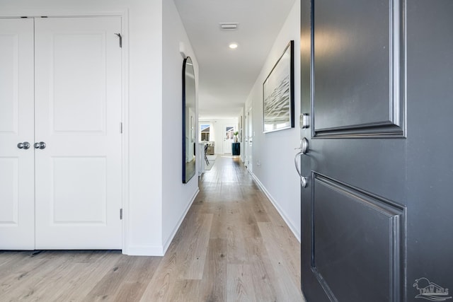 corridor featuring light wood-type flooring, baseboards, and recessed lighting