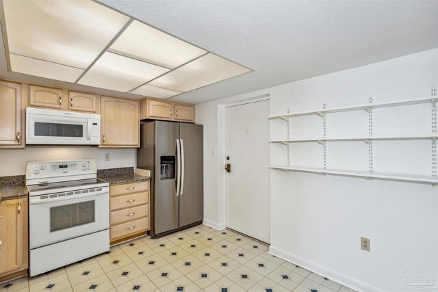 kitchen with light brown cabinetry, white appliances, and sink