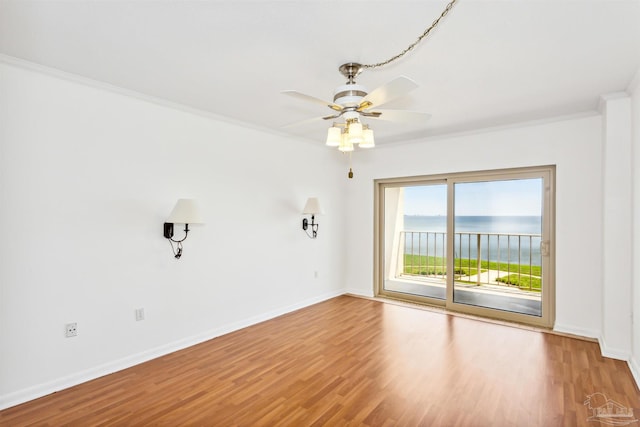 empty room with crown molding, light hardwood / wood-style flooring, a water view, and ceiling fan