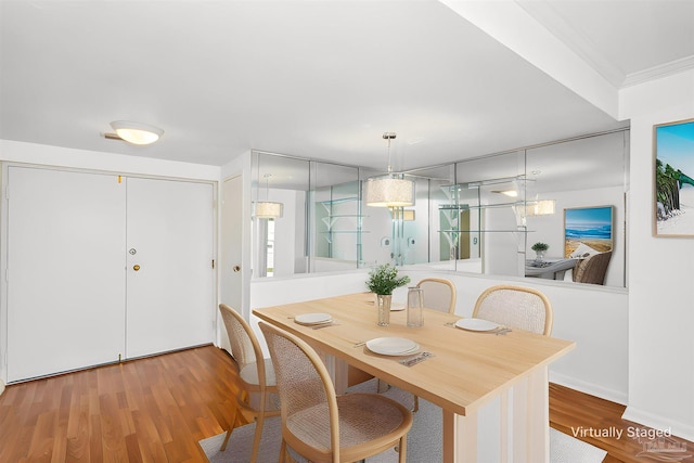 dining area featuring ornamental molding and wood finished floors