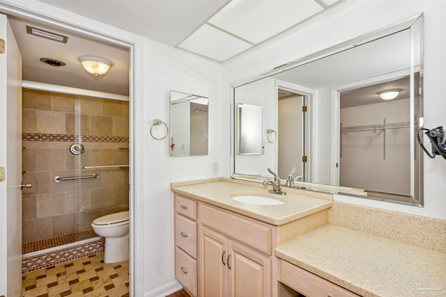 bathroom with vanity, toilet, and a shower with shower door