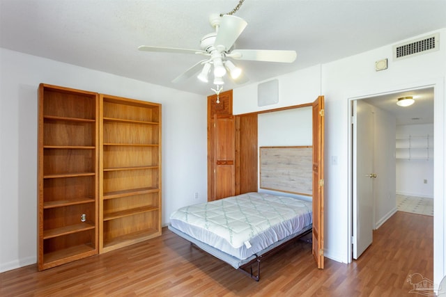 bedroom with hardwood / wood-style floors, a textured ceiling, and ceiling fan