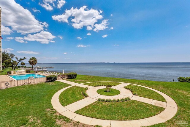 exterior space featuring a water view, a yard, and a swimming pool