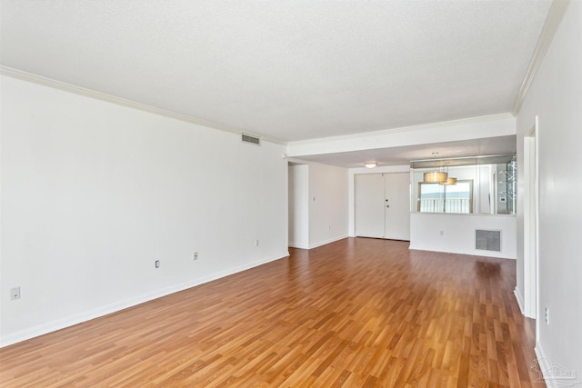 interior space featuring hardwood / wood-style floors, a textured ceiling, and ornamental molding