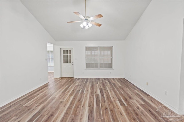 unfurnished living room featuring light wood-type flooring, vaulted ceiling, and ceiling fan