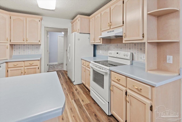 kitchen with a textured ceiling, light brown cabinetry, white appliances, and light wood-type flooring