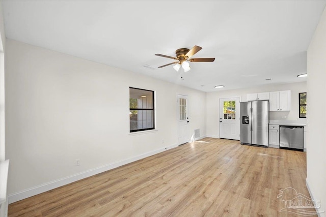 unfurnished living room featuring ceiling fan and light wood-type flooring