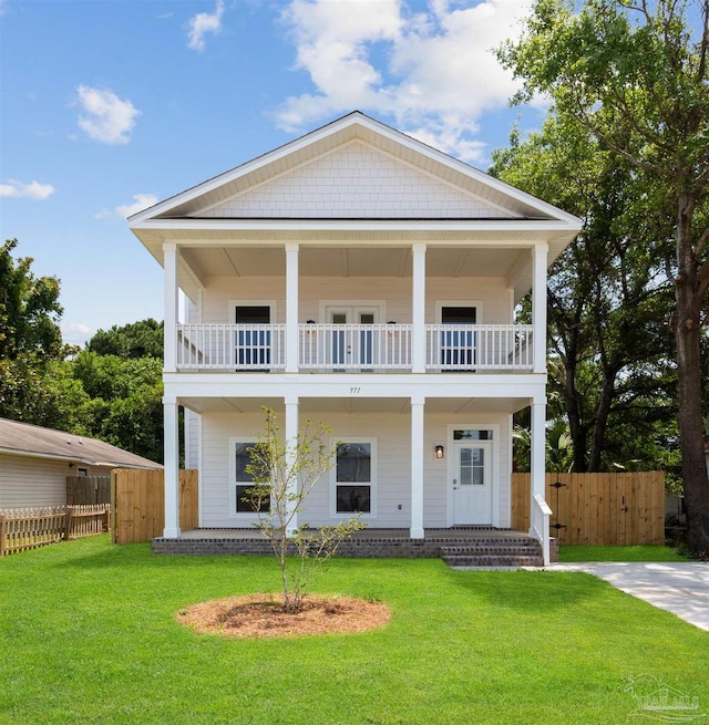 view of front of home featuring a balcony and a front yard