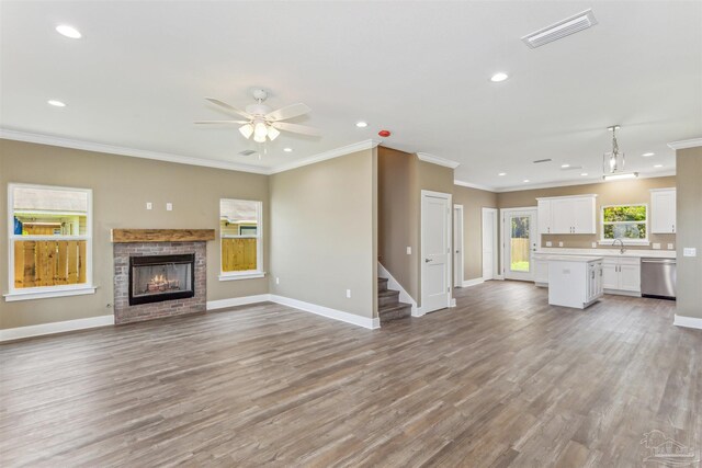 unfurnished living room featuring ornamental molding, a fireplace, and hardwood / wood-style flooring