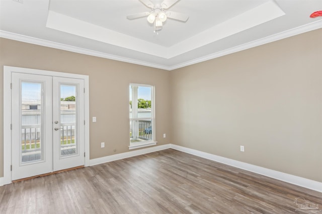 spare room featuring ornamental molding, hardwood / wood-style floors, french doors, and a raised ceiling