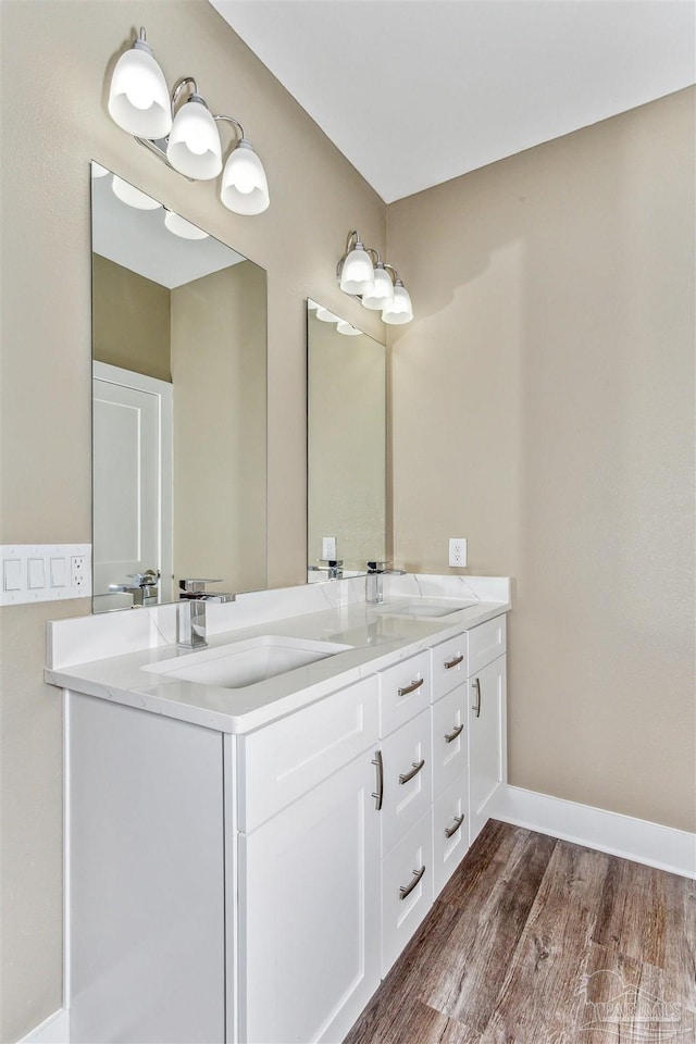 bathroom featuring double vanity and hardwood / wood-style flooring