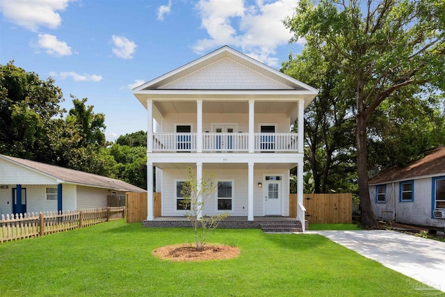 view of front facade featuring a balcony and a front yard