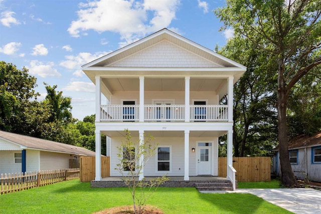 view of front of property featuring a balcony and a front yard