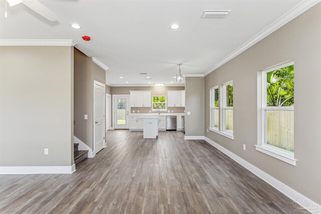 unfurnished living room with ceiling fan, sink, hardwood / wood-style flooring, and ornamental molding