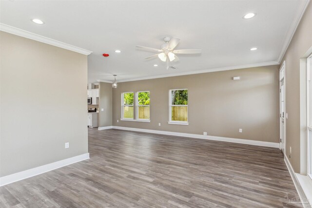 empty room with crown molding, ceiling fan, and wood-type flooring