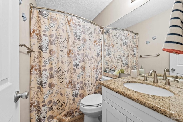 bathroom with a shower with curtain, vanity, a textured ceiling, and toilet