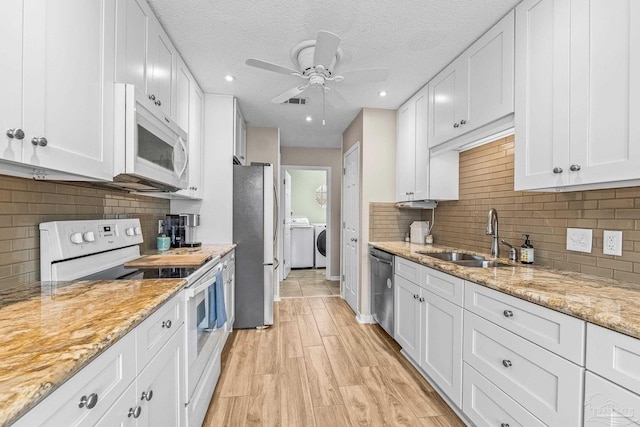 kitchen with white cabinetry, sink, stainless steel appliances, and light stone countertops