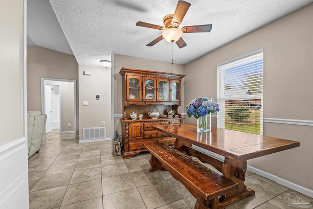 dining room featuring light tile patterned floors, a textured ceiling, and ceiling fan