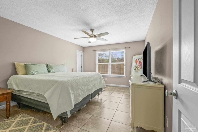 bedroom with ceiling fan, a textured ceiling, and light tile patterned floors