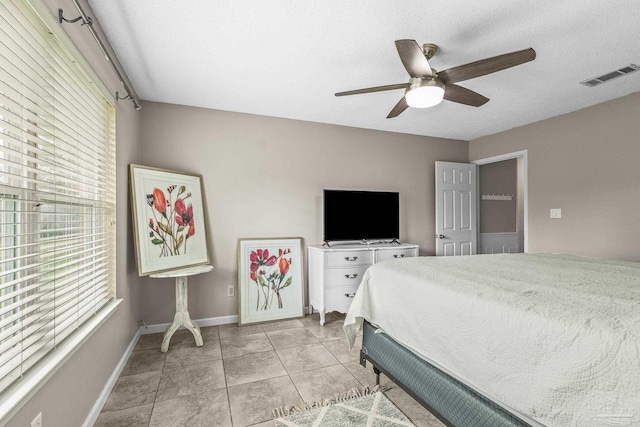 tiled bedroom featuring a textured ceiling and ceiling fan