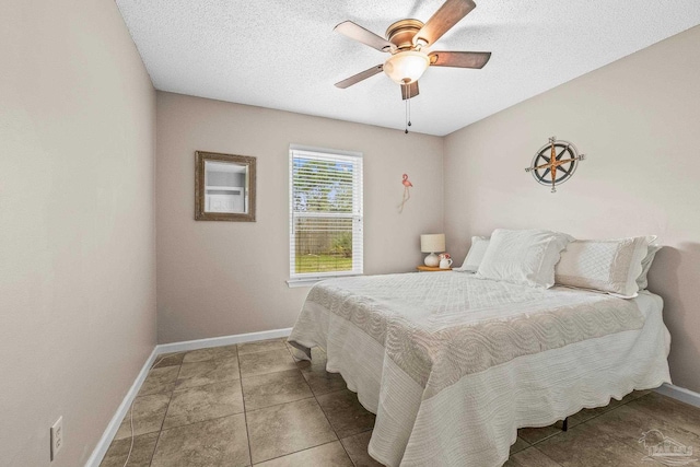 tiled bedroom with a textured ceiling and ceiling fan