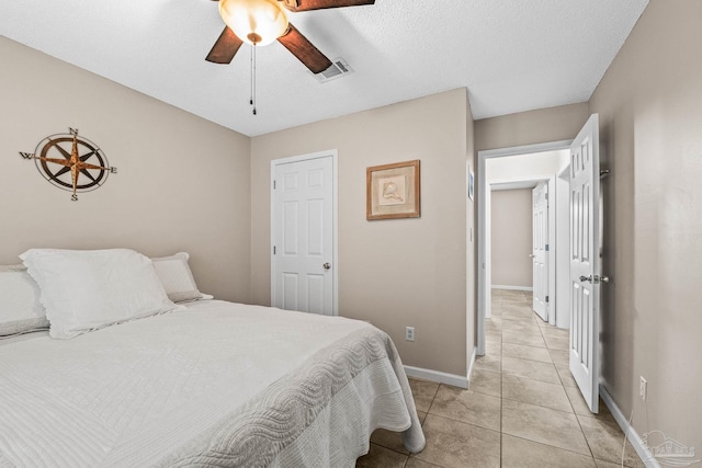 bedroom with ceiling fan, a textured ceiling, and light tile patterned floors