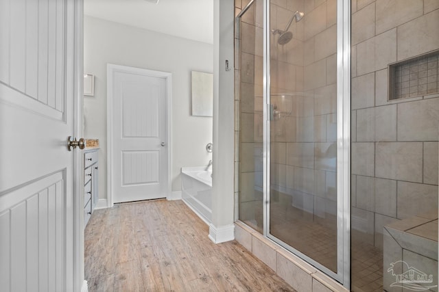 6347 Ladera Trl, Pace, FL 32571 - full bathroom featuring a stall shower, wood finished floors, a garden tub, and baseboards