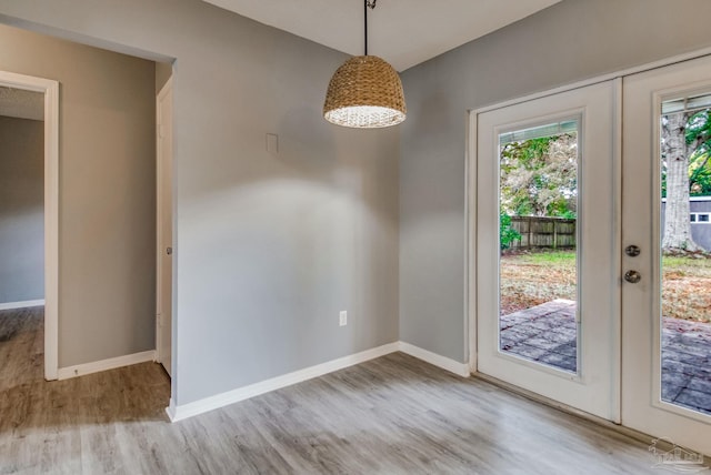 unfurnished dining area featuring french doors, light hardwood / wood-style flooring, and a wealth of natural light