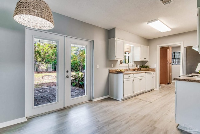 kitchen with dishwasher, white cabinetry, and french doors