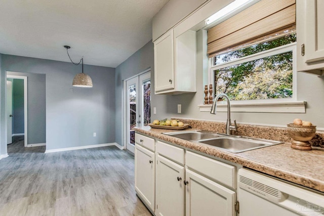 kitchen with dishwasher, white cabinets, pendant lighting, and sink