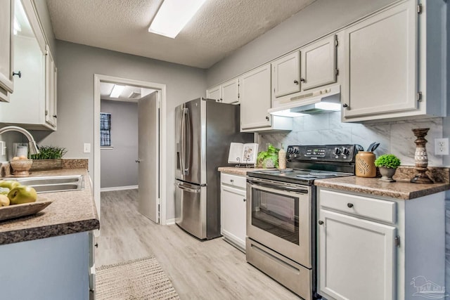 kitchen featuring white cabinets, a textured ceiling, stainless steel appliances, and sink