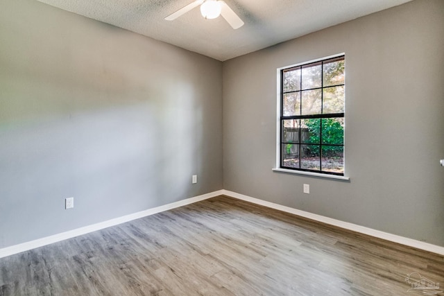 unfurnished room with a textured ceiling, hardwood / wood-style flooring, and ceiling fan