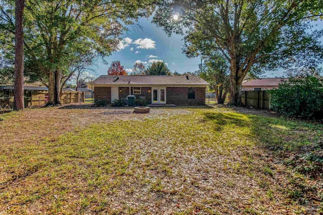 rear view of house with a lawn and french doors