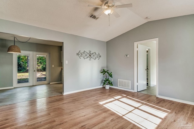 spare room featuring a textured ceiling, ceiling fan, hardwood / wood-style floors, and vaulted ceiling