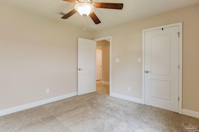 empty room featuring ceiling fan and light colored carpet