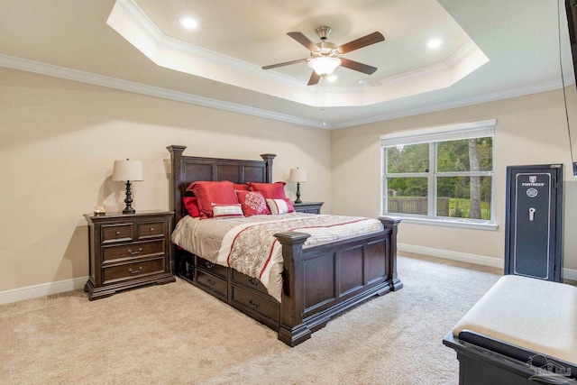 carpeted bedroom featuring ceiling fan, a tray ceiling, and crown molding