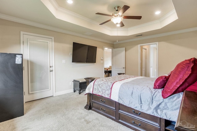 bedroom with ornamental molding, a tray ceiling, ceiling fan, and light colored carpet