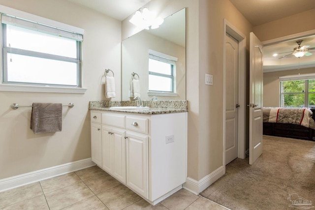 bathroom with a healthy amount of sunlight, tile patterned floors, ceiling fan, and vanity