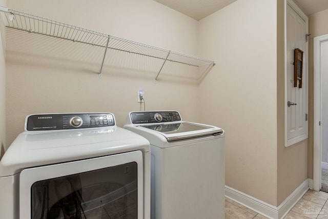 laundry area with light tile patterned floors and independent washer and dryer