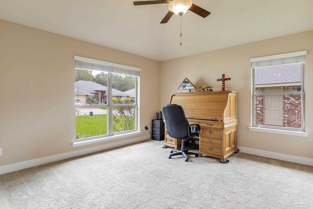 carpeted office space featuring ceiling fan