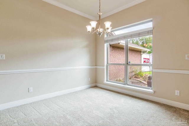 carpeted spare room with ornamental molding and a chandelier