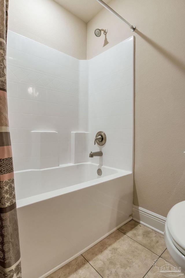 bathroom featuring shower / bath combo with shower curtain, tile patterned floors, and toilet