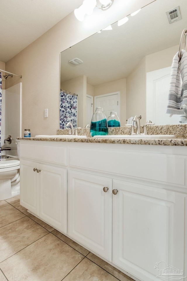 bathroom with tile patterned floors, curtained shower, vanity, and toilet