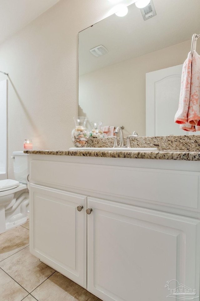 bathroom featuring vanity, toilet, and tile patterned floors