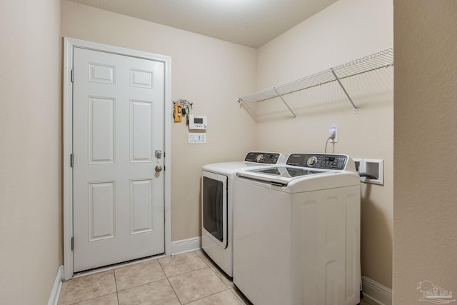 washroom featuring light tile patterned flooring and washer and dryer