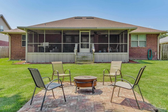 back of house featuring a fire pit, a sunroom, a yard, and a patio area