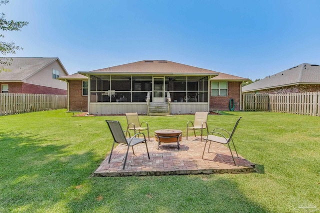 back of property featuring a patio, a yard, a sunroom, and an outdoor fire pit