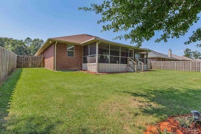 back of property featuring a lawn and a sunroom