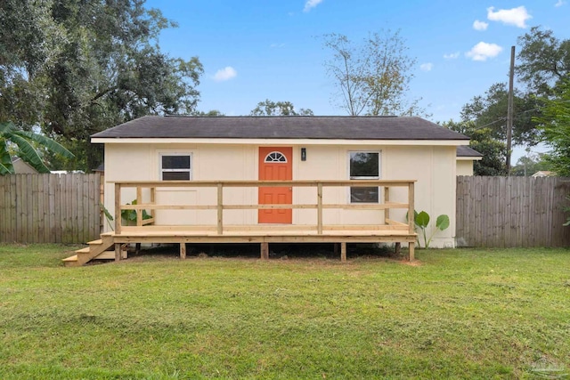 back of house featuring a deck and a yard