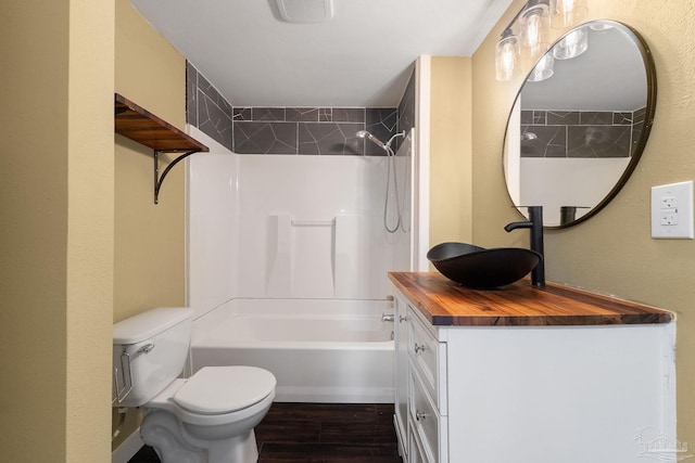 full bathroom featuring hardwood / wood-style floors, vanity, tiled shower / bath combo, and toilet